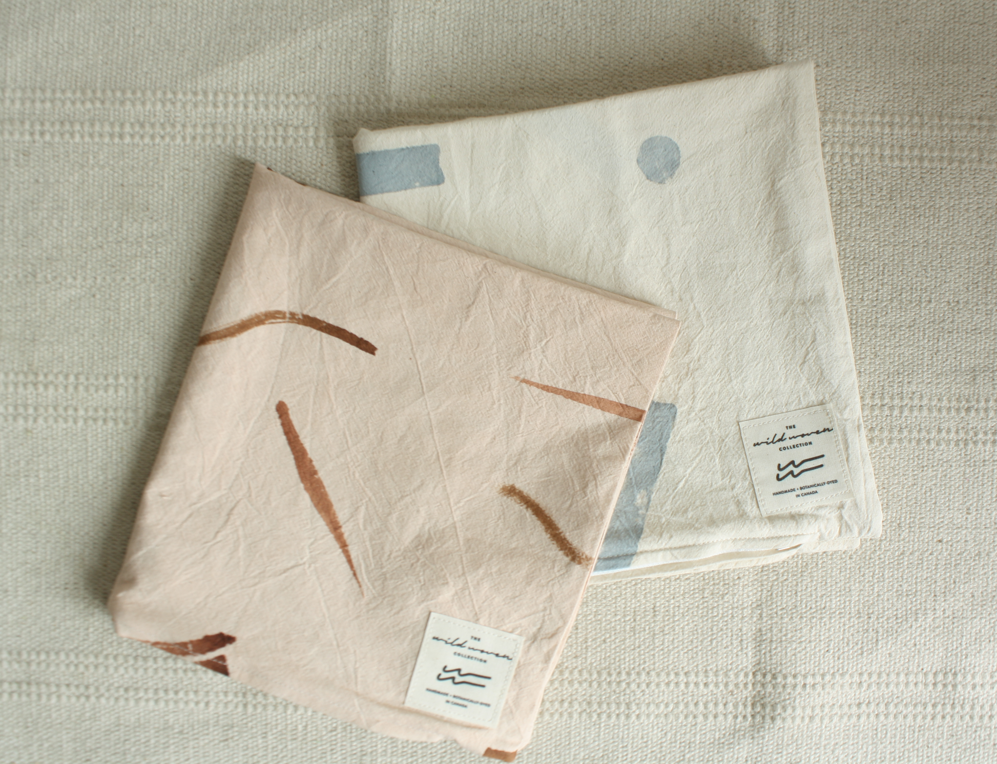 Two organic cotton botanically dyed pillow cases folded and stacked one on top of the other.