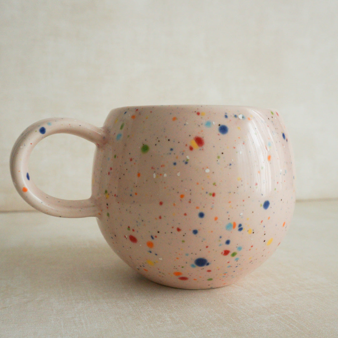 Pink speckled mug with playful confetti pattern