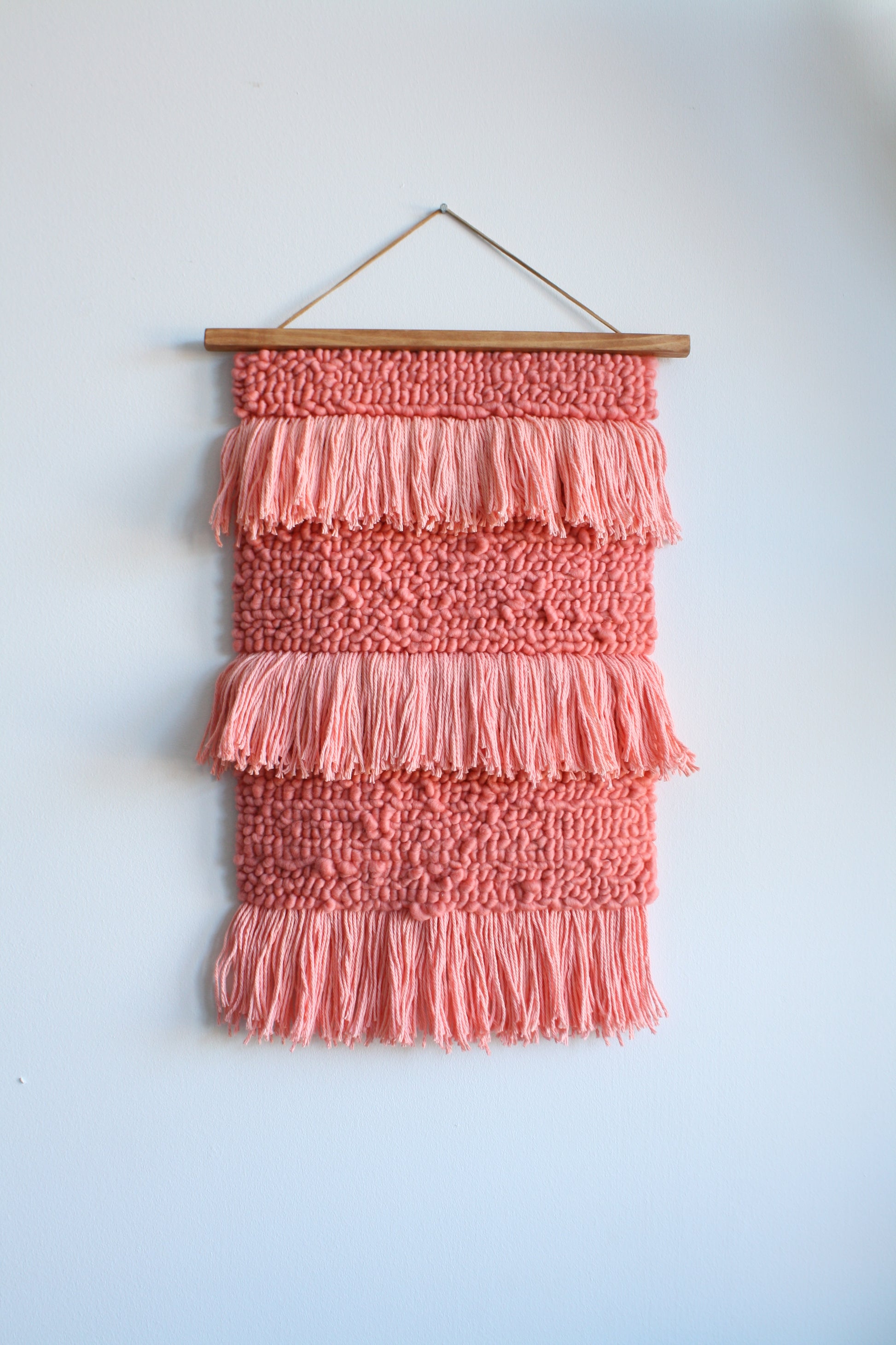 Handmade bohemian wall hanging in soft pink wool fibers