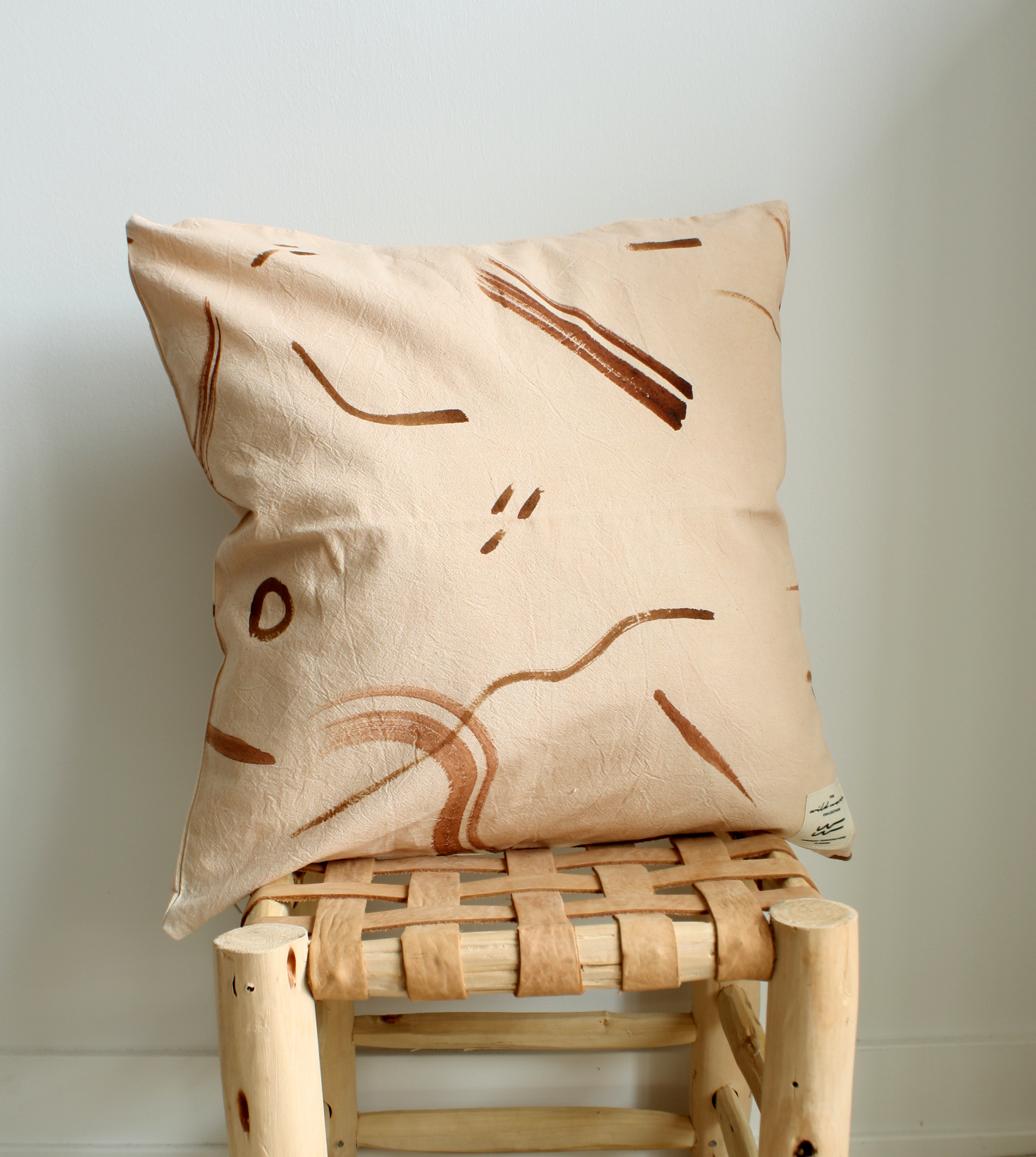 A single pink and brown botanically dyed throw pillow.